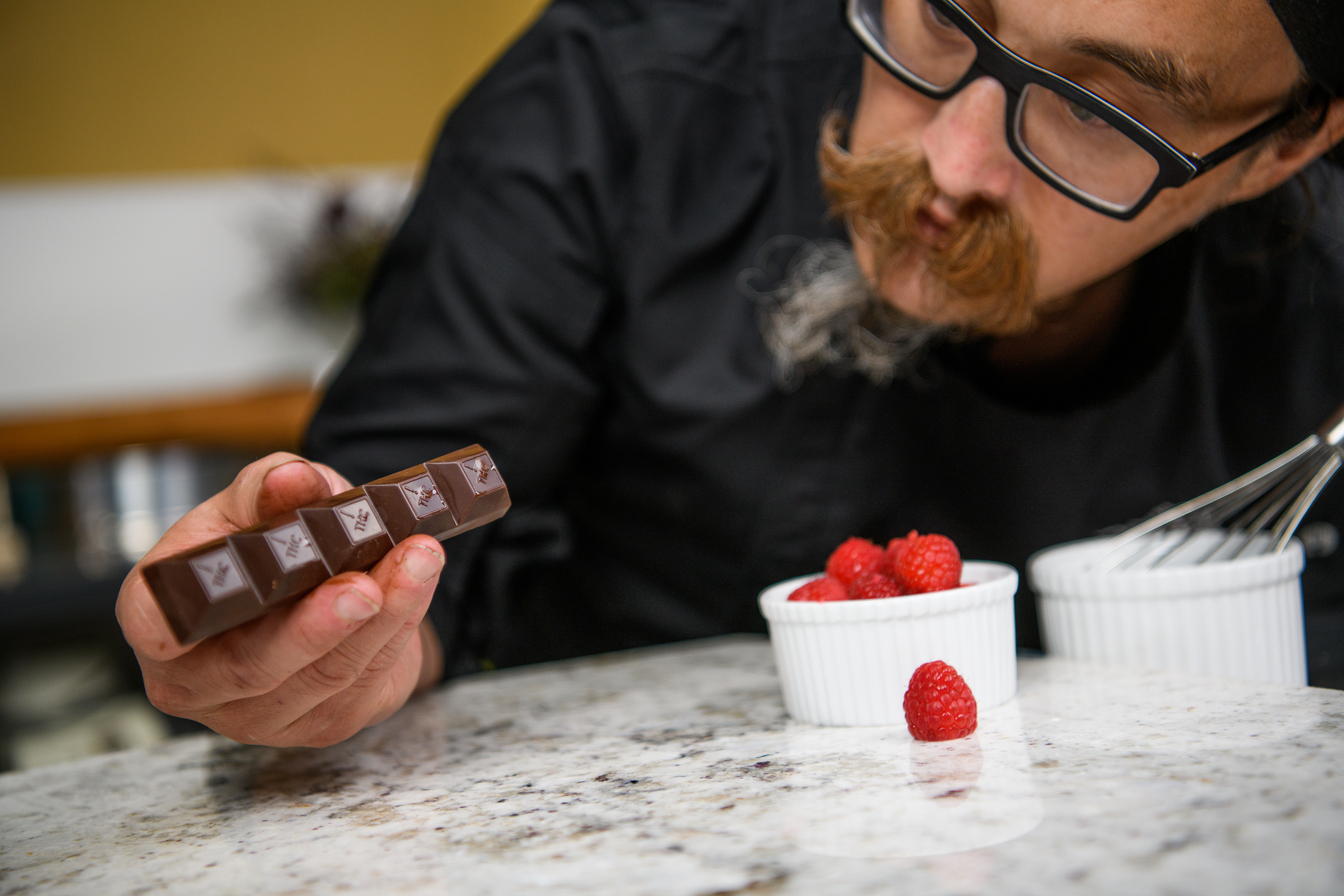Medically Correct Co-Founder and Executive Chef, Josh Fink, is examining a Nove luxury cannabis chocolate bar.