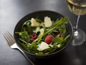 A rocket salad topped with parmesan, almonds, and raspberries.  The infused Raspberry Chocolate Salad by Nove is a must-try.
