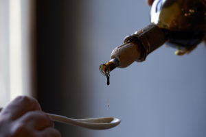 Tasting of balsamic vinegar on a ceramic spoon