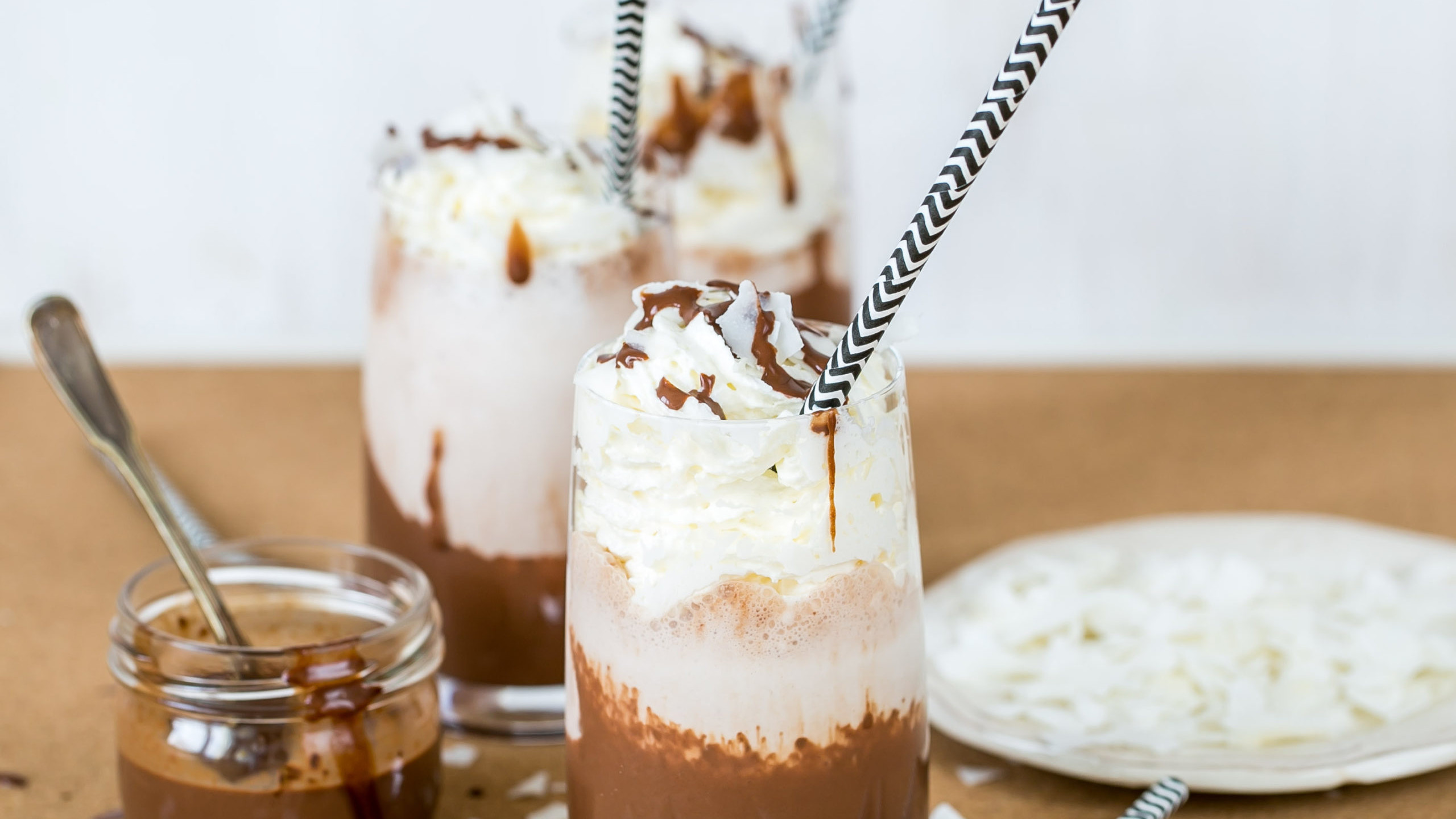 Three frozen hot chocolates topped with whipped cream and striped straws. This cannabis recipe features Nove Glacier Mint.