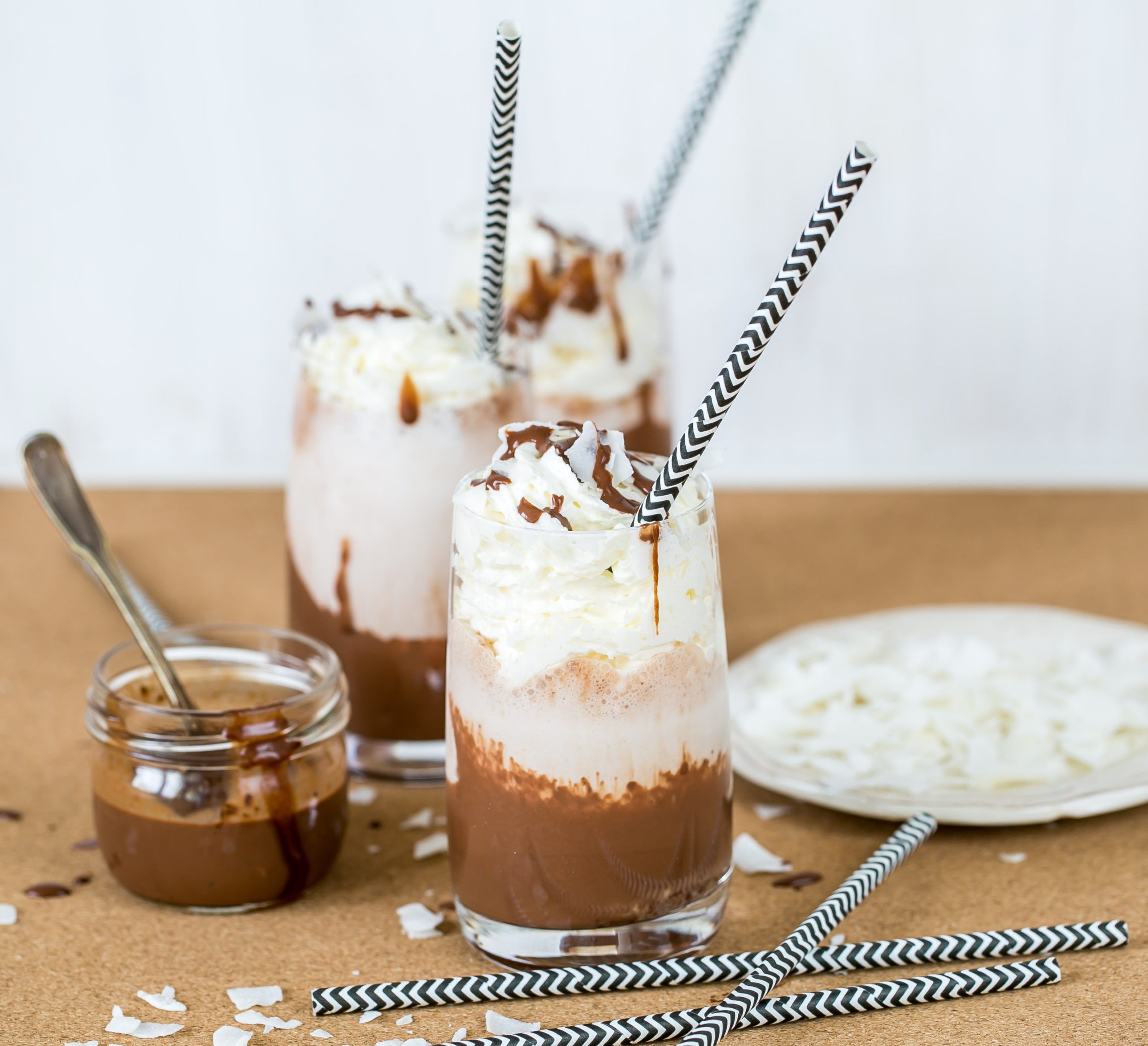 Three frozen hot chocolates topped with whipped cream and striped straws. This cannabis recipe features Nove Glacier Mint.