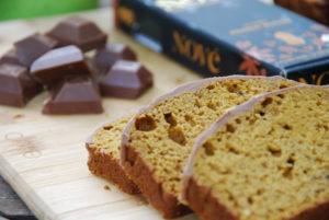 Cannabis-Infused Pumpkin Bread slices resting on a wood surface next to a Nove Honey Peanut Butter bar.